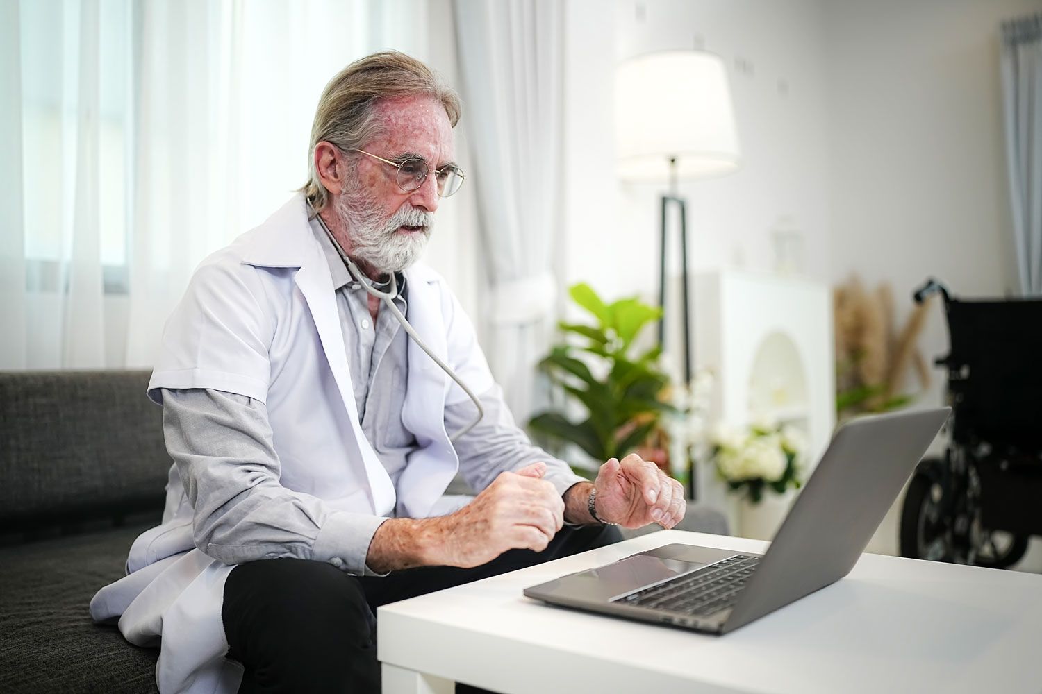An older doctor using a laptop for medical work